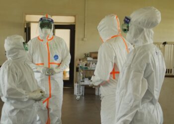 Health workers in protective gear during an Ebola response operation.