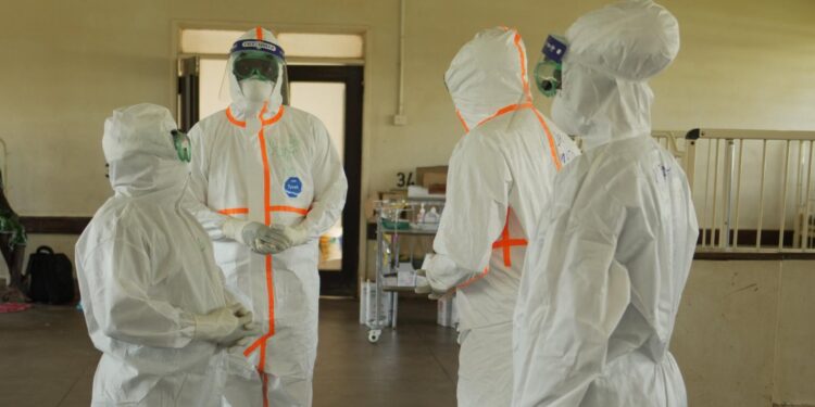 Health workers in protective gear during an Ebola response operation.