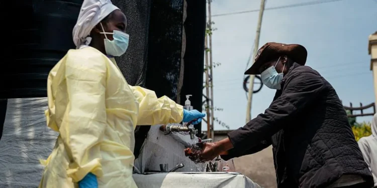 Visitors and patients wash their hands and undergo temperature checks before entering Kyeshero Hospital in Goma.