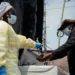Visitors and patients wash their hands and undergo temperature checks before entering Kyeshero Hospital in Goma.