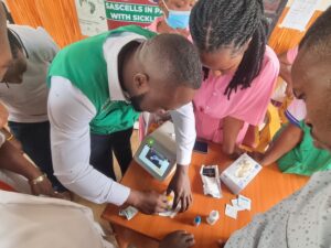 Sarafinah Sickle Cell Society Field Officer training medical workers at Goma HCIII how to use new machines.