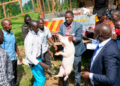 Ahmed Nyombi Mukiibi, the Kalungu District LC5 Chairperson, carries one of the pigs during an Operation Wealth Creation (OWC) livestock distribution exercise in Kalungu District recently.