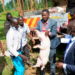 Ahmed Nyombi Mukiibi, the Kalungu District LC5 Chairperson, carries one of the pigs during an Operation Wealth Creation (OWC) livestock distribution exercise in Kalungu District recently.