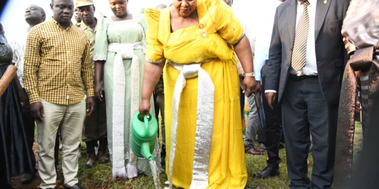 Minister for the Presidency, Hon. Milly Babirye Babalanda, plants a tree at Namagera Town Council Headquarters during the Jinja District Women's Day celebrations.