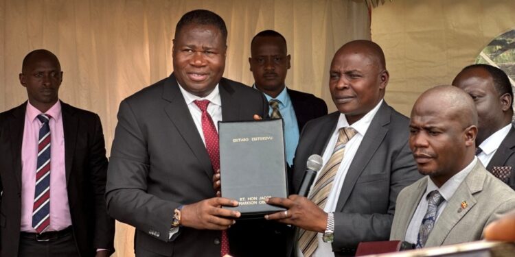 The Rt Hon Speaker of Uganda Jacob Markson Oboth receiving a bible from Pastor Samuel Lwandasa during Prayer and Thanksgiving Ceremony organized by Greater Mukono Inter Faith Forum.