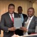 The Rt Hon Speaker of Uganda Jacob Markson Oboth receiving a bible from Pastor Samuel Lwandasa during Prayer and Thanksgiving Ceremony organized by Greater Mukono Inter Faith Forum.