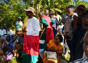Nalongo Maggie Kaweesi sits beside 'Kabaka' Nakibinge as he addresses residents during a meeting at a contested piece of land.