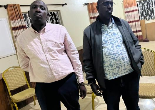 Sembabule District Land Board Secretary Michael Kakuru (in jacket) and Emmanuel Kananura, the Senior Land Management Officer, after their arrest on Thursday over allegations linked to corruption and abuse of office.
