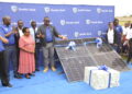 Stanbic's Executive Head of Business and Commercial Banking, Tunde Thorpe, handing over a gift to the acting District Education Officer, Joy Wamalugu