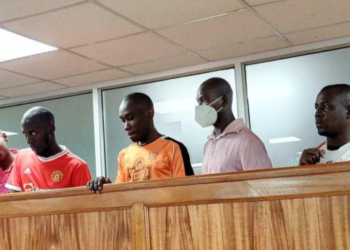 Ibrah Muwonge (centre) with his co-accused during an earlier court appearance in the case involving the destruction of electricity infrastructure.