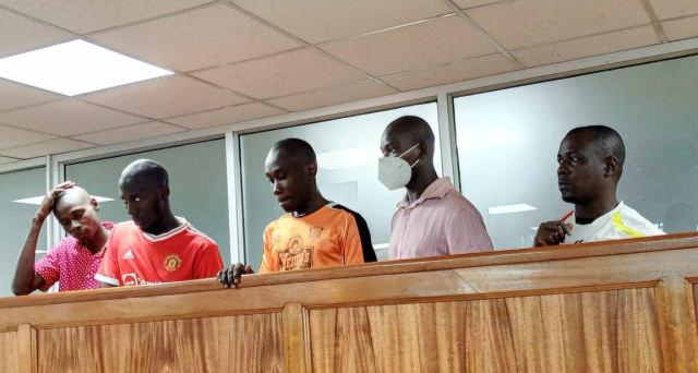 Ibrah Muwonge (centre) with his co-accused during an earlier court appearance in the case involving the destruction of electricity infrastructure.